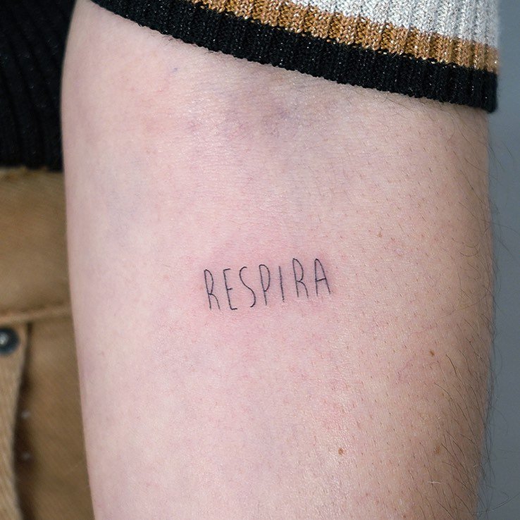 Tatuaje de frase en muslo, línea fina Sinkply Madrid