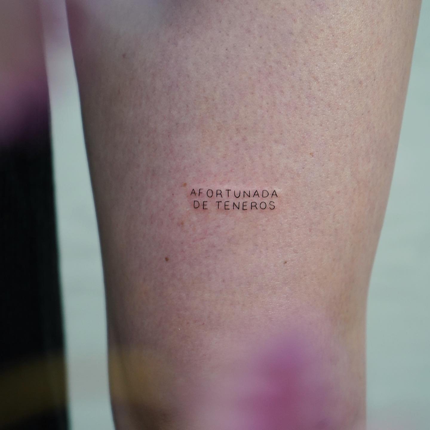 Tatuaje de frase en muslo, línea fina Sinkply Madrid