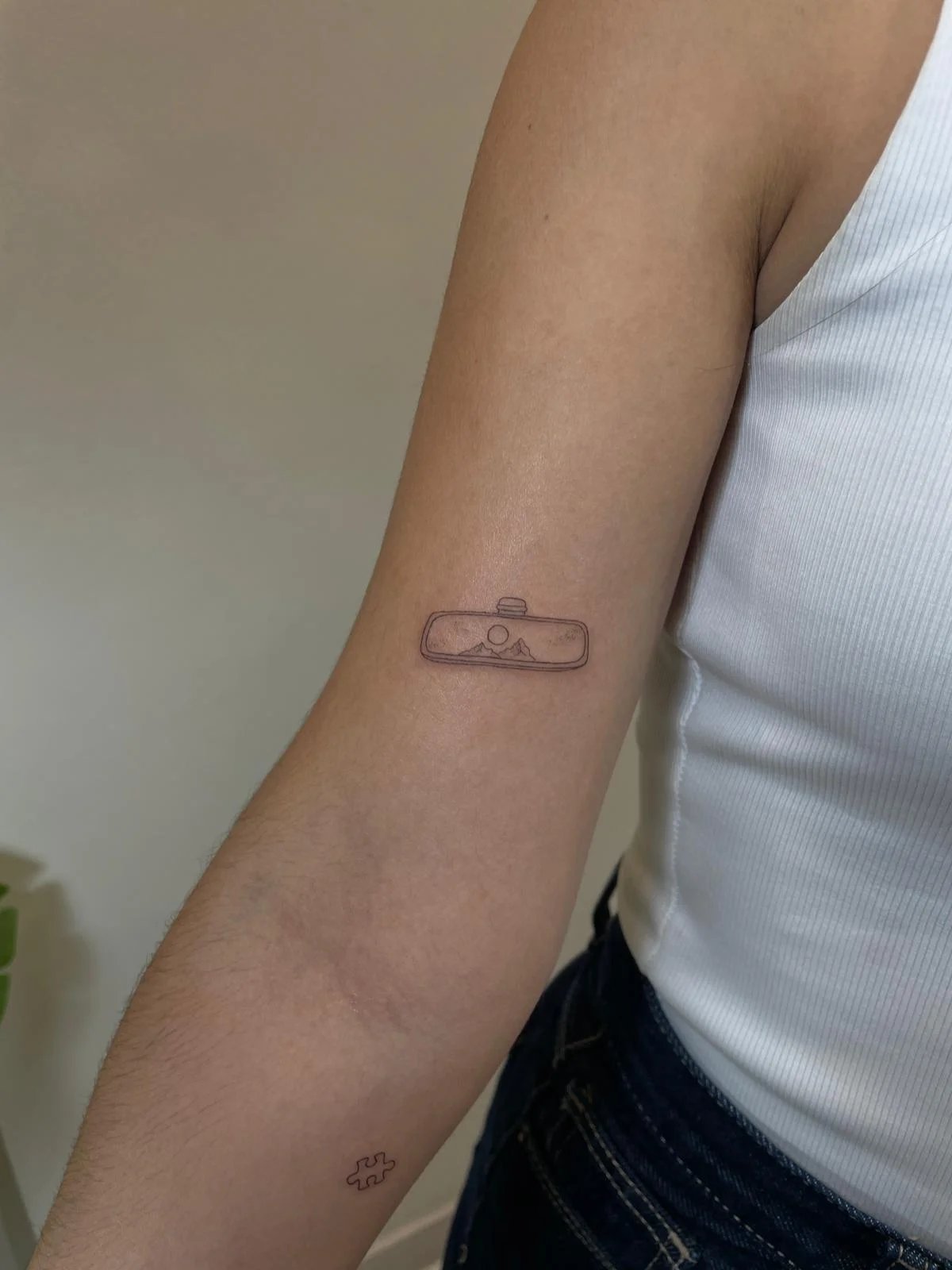 Tatuaje paisaje montanas sol geometrico fine line antebrazo