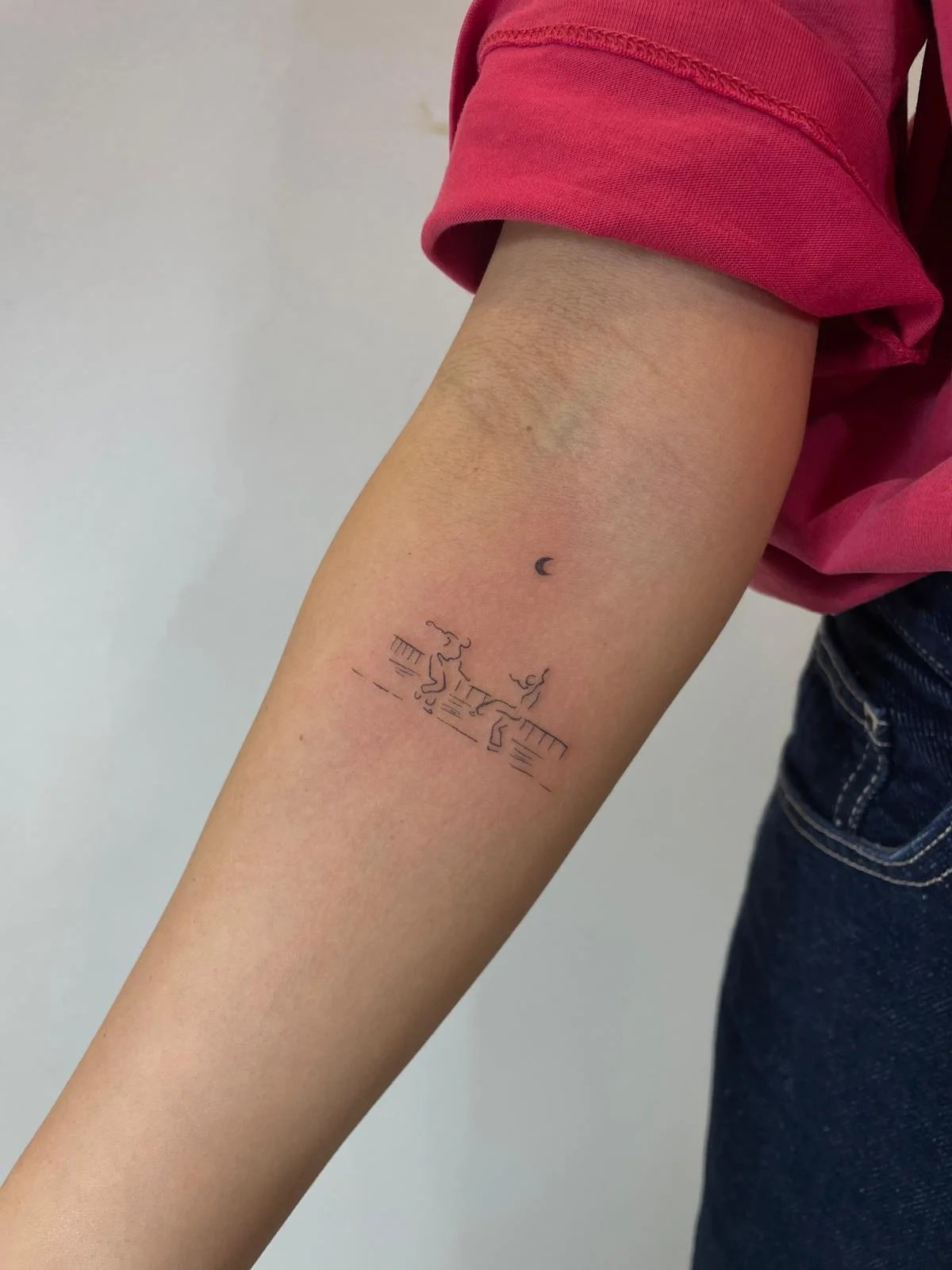 Tatuaje retrato-silueta escena playa minimalista antebrazo