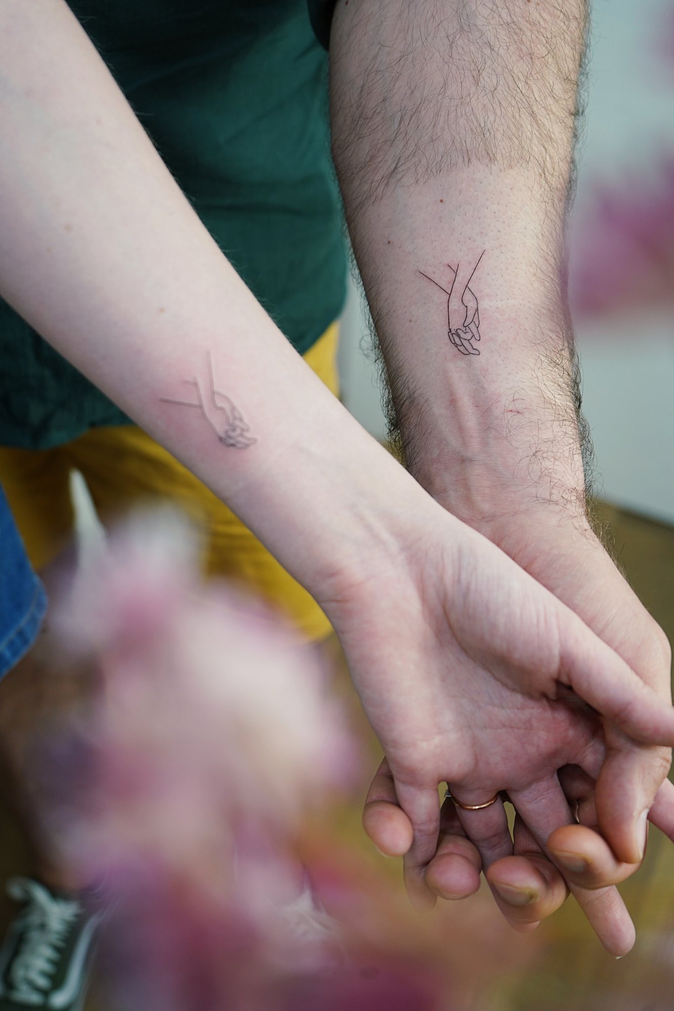 Tatuaje de manos entrelazadas en zona desconocida, línea fina