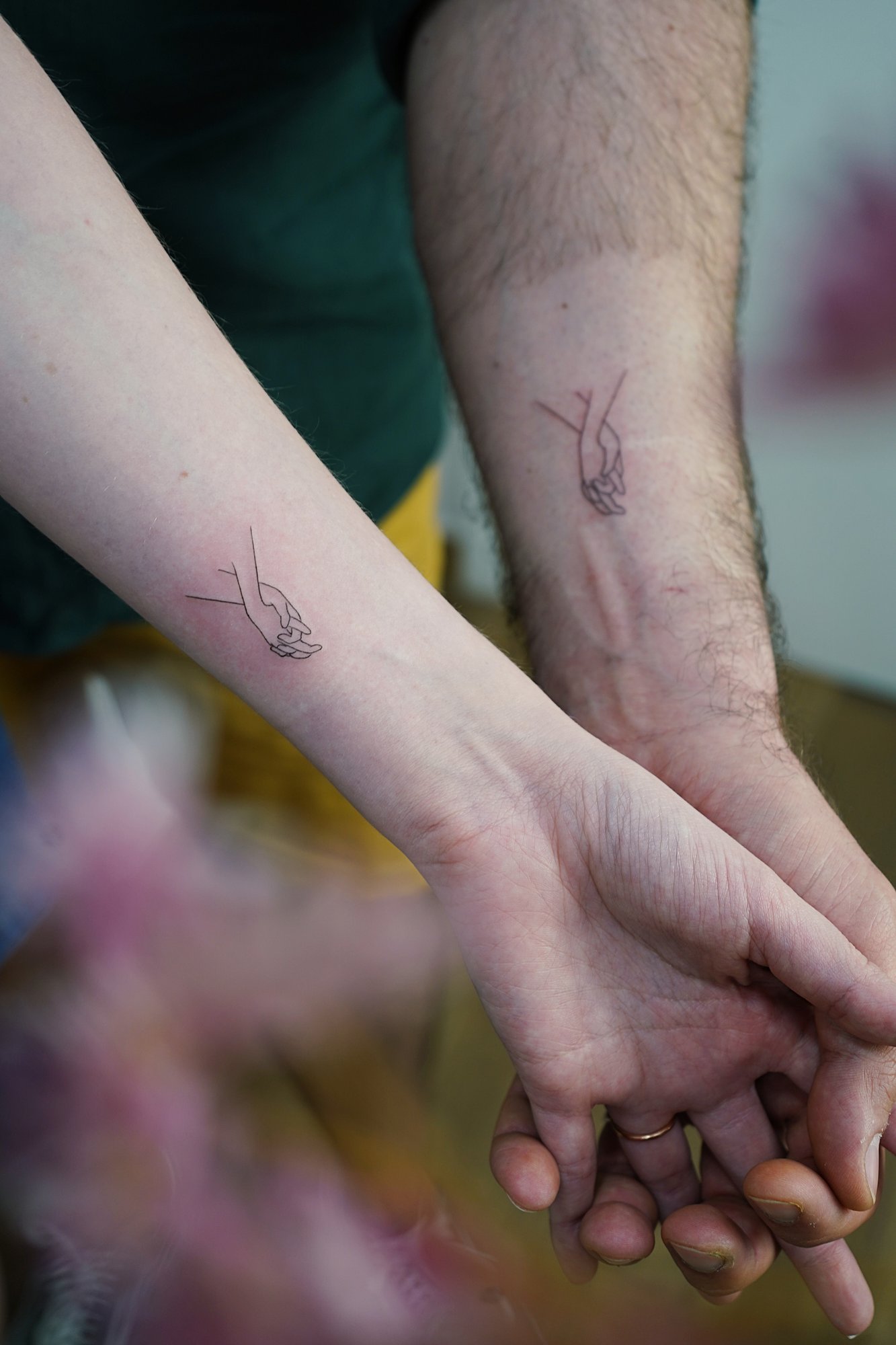 Tatuaje de manos entrelazadas en zona desconocida, línea fina
