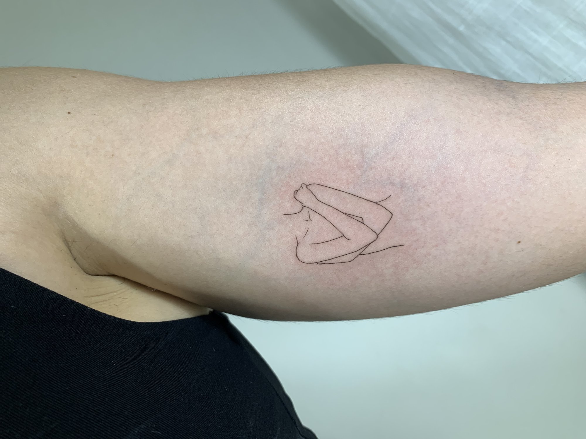 Tatuaje de silueta femenina abrazandose en brazo, línea fina