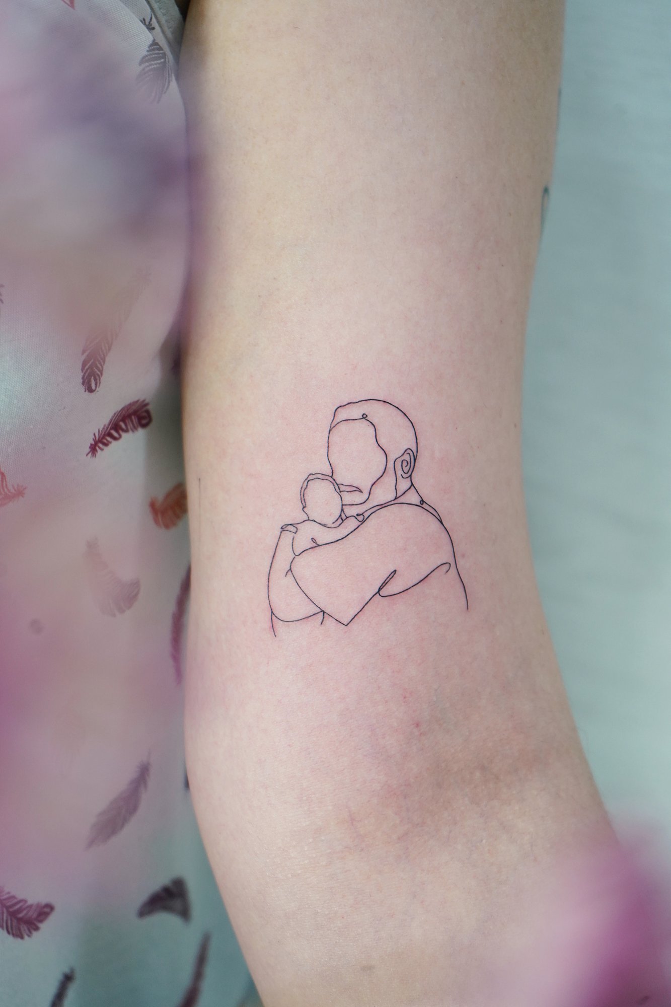 Tatuaje de silueta en biceps, línea fina