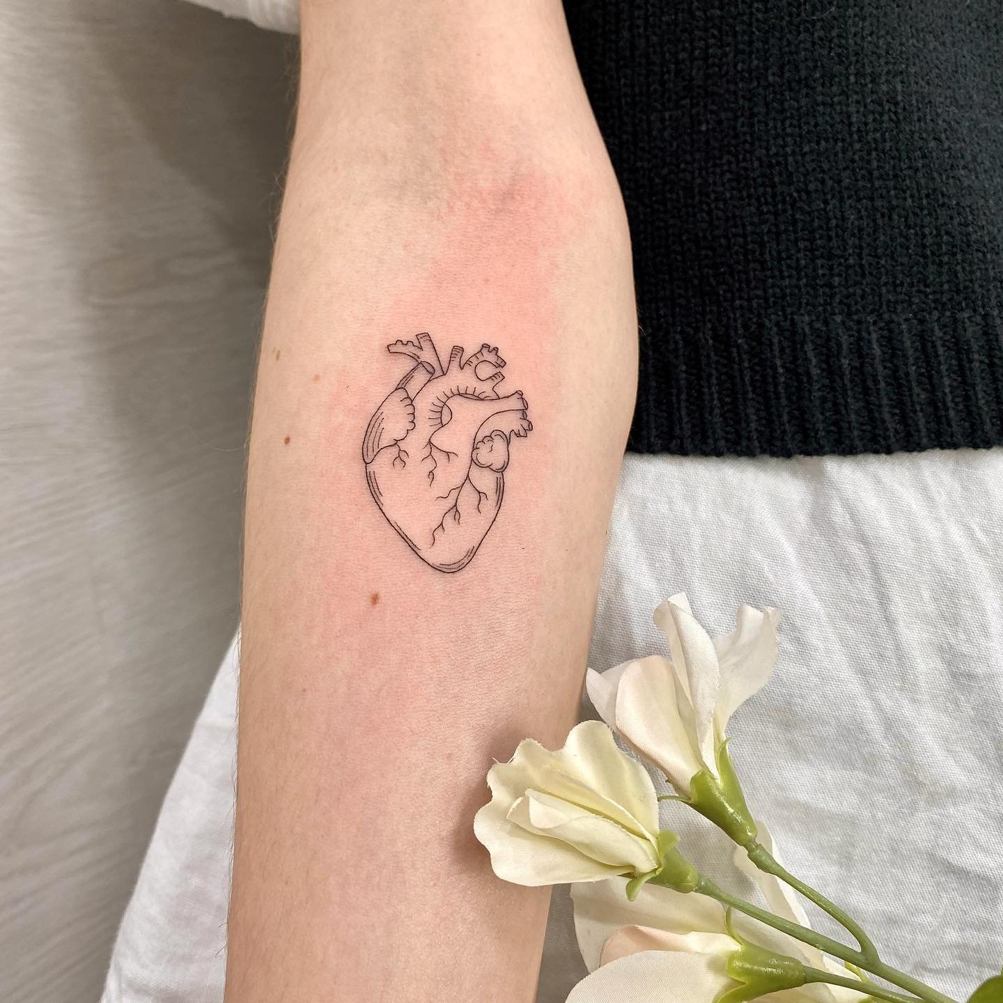 Tatuaje de corazon en antebrazo, línea fina Sinkply Madrid