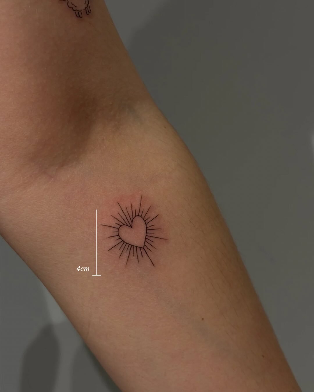 Tatuaje de corazon en brazo, línea fina Sinkply Madrid