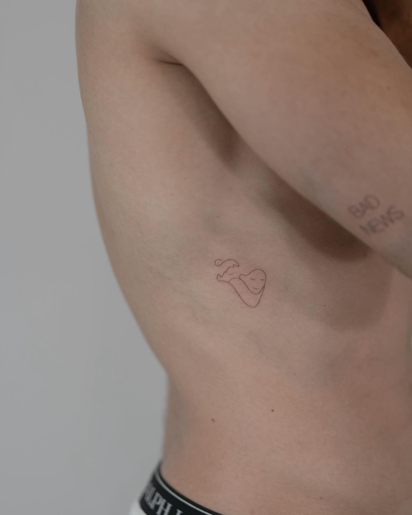 Tatuaje de corazon en costilla, línea fina Sinkply Madrid