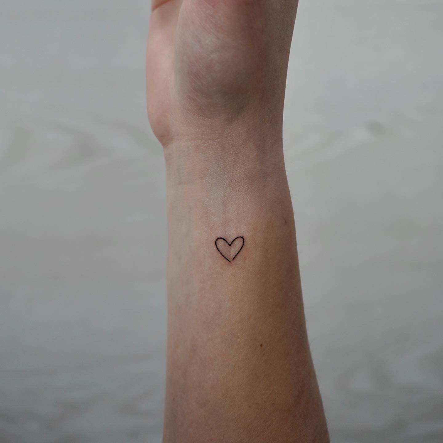 Tatuaje de corazon en muneca, línea fina Sinkply Madrid