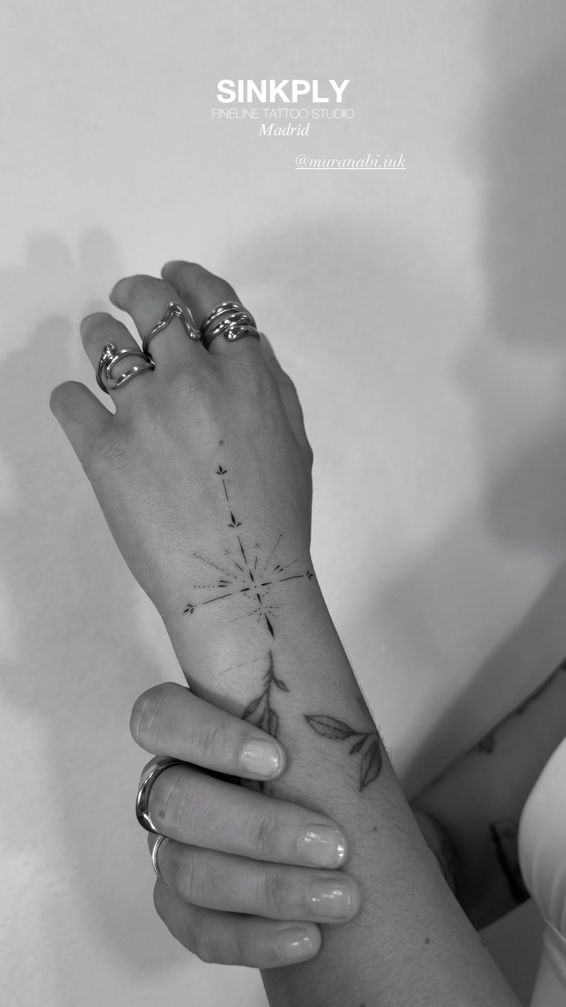 Tatuaje de estrella ornamental y hojas en mano, línea fina