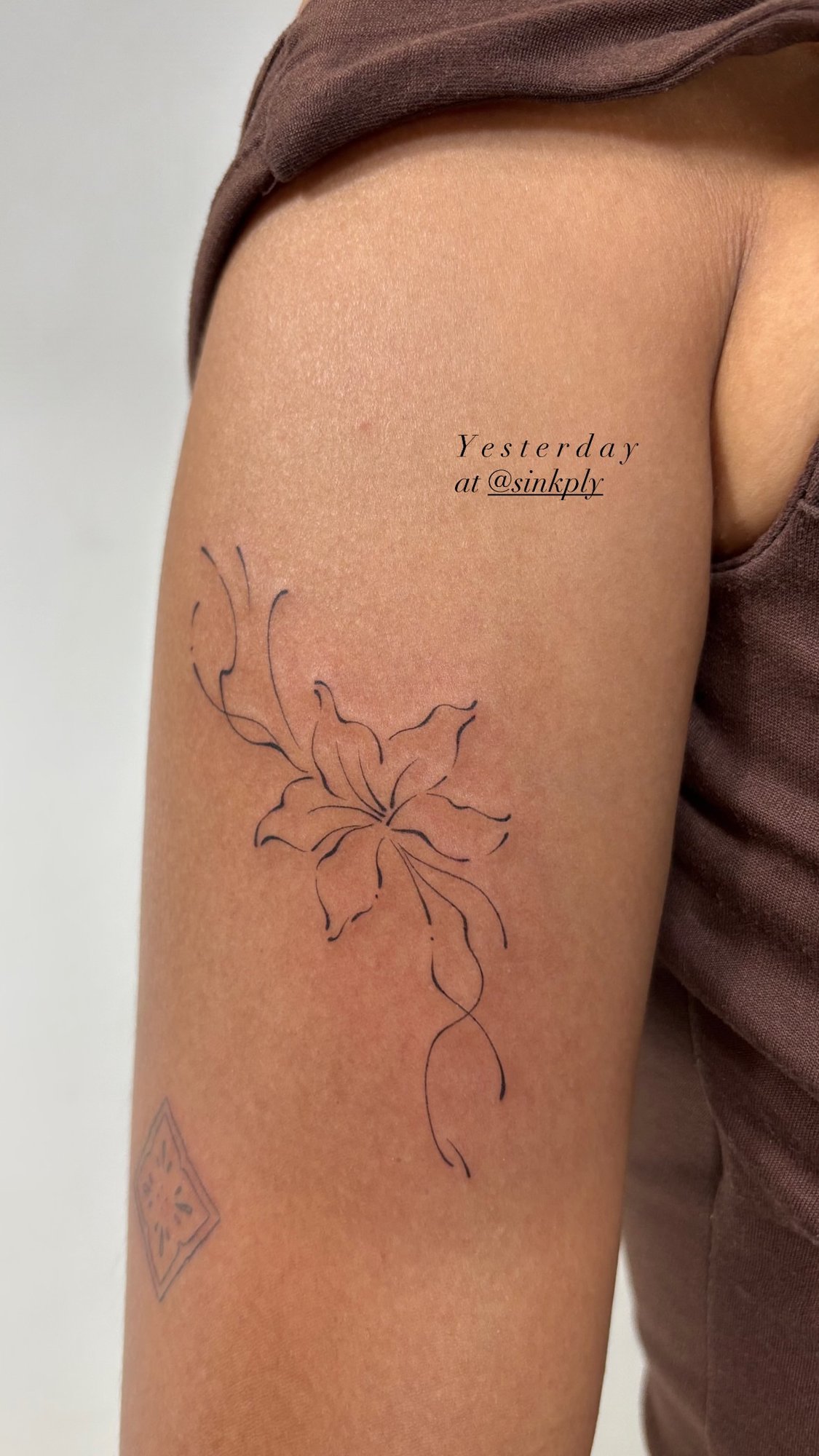 Tatuaje de lirio lineal y geométrico en brazo, línea fina