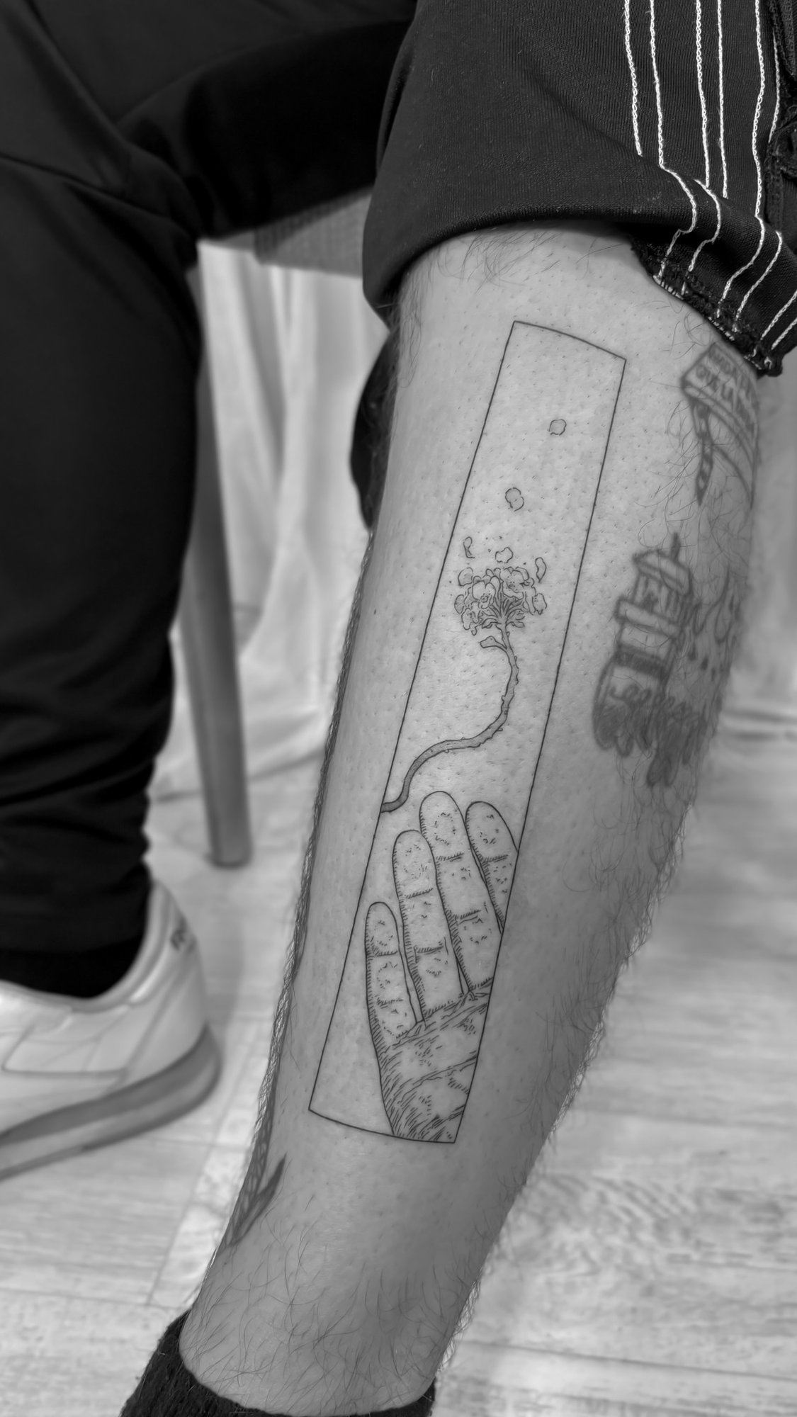 Tatuaje de mano con arbol panel en pierna, línea fina