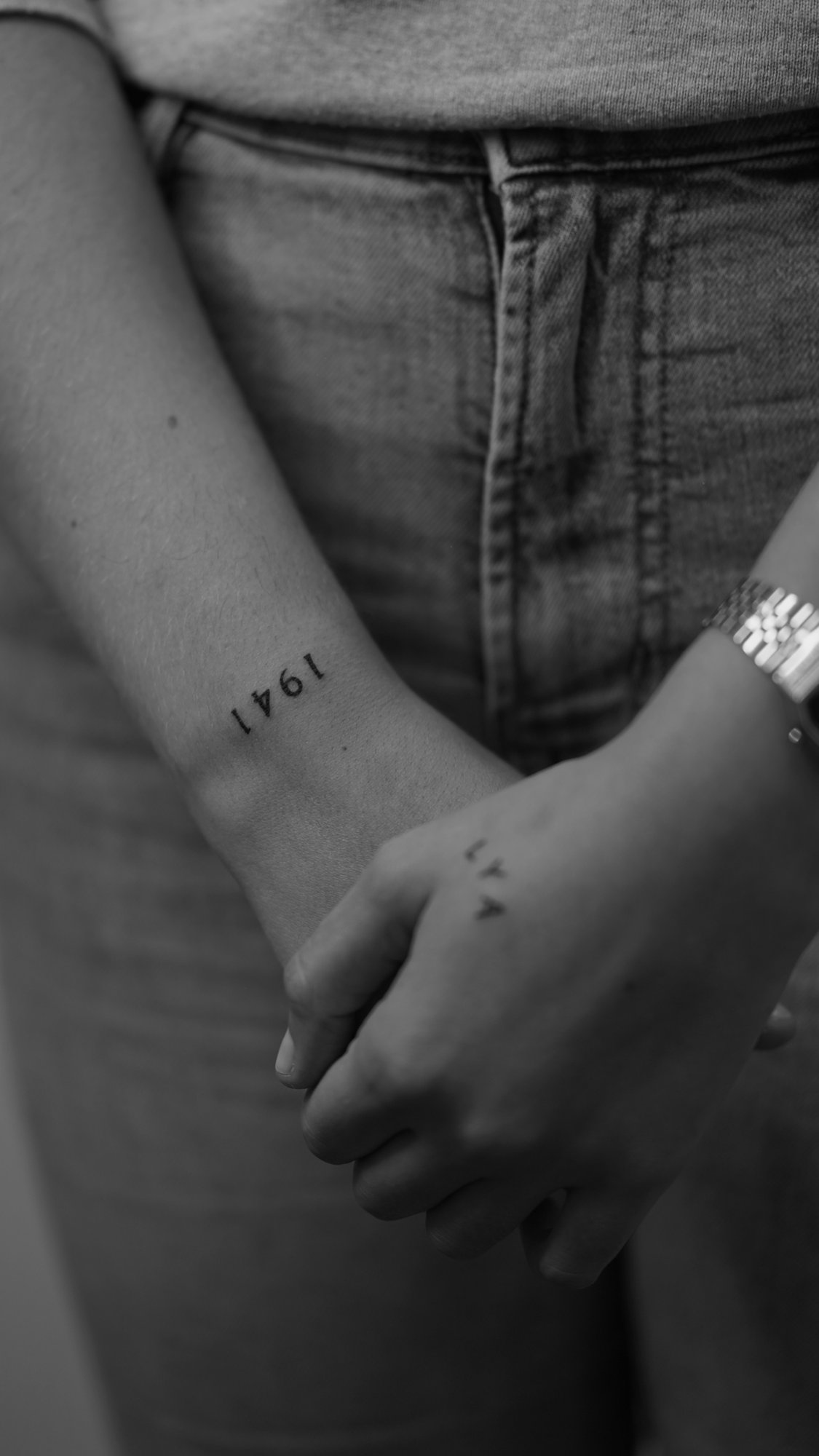Tatuaje de numero 1941 y letras en muneca, línea fina