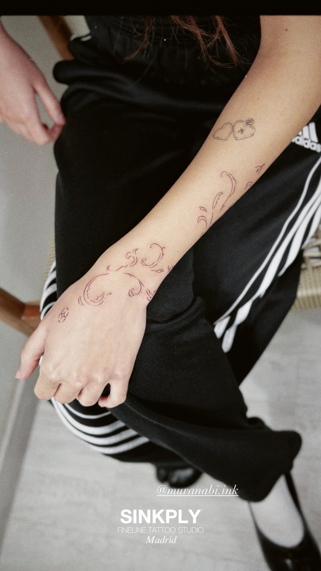 Tatuaje de ornamental rojo y corazones en antebrazo, línea fina