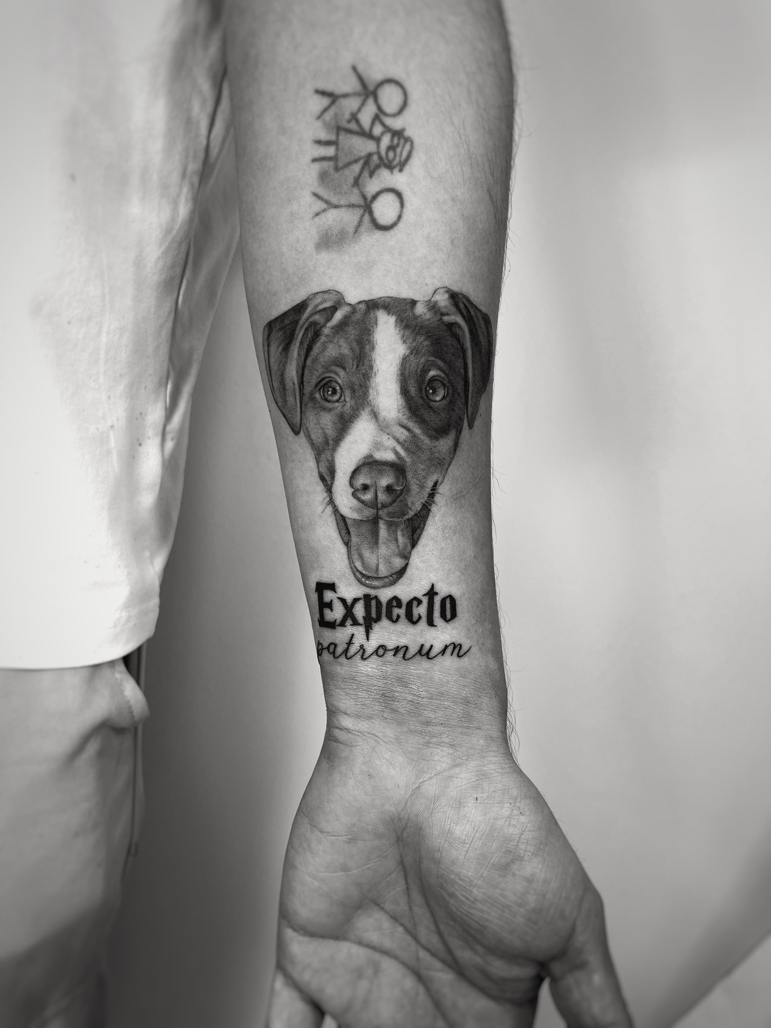 Tatuaje de retrato perro expecto patronum en antebrazo, línea fina