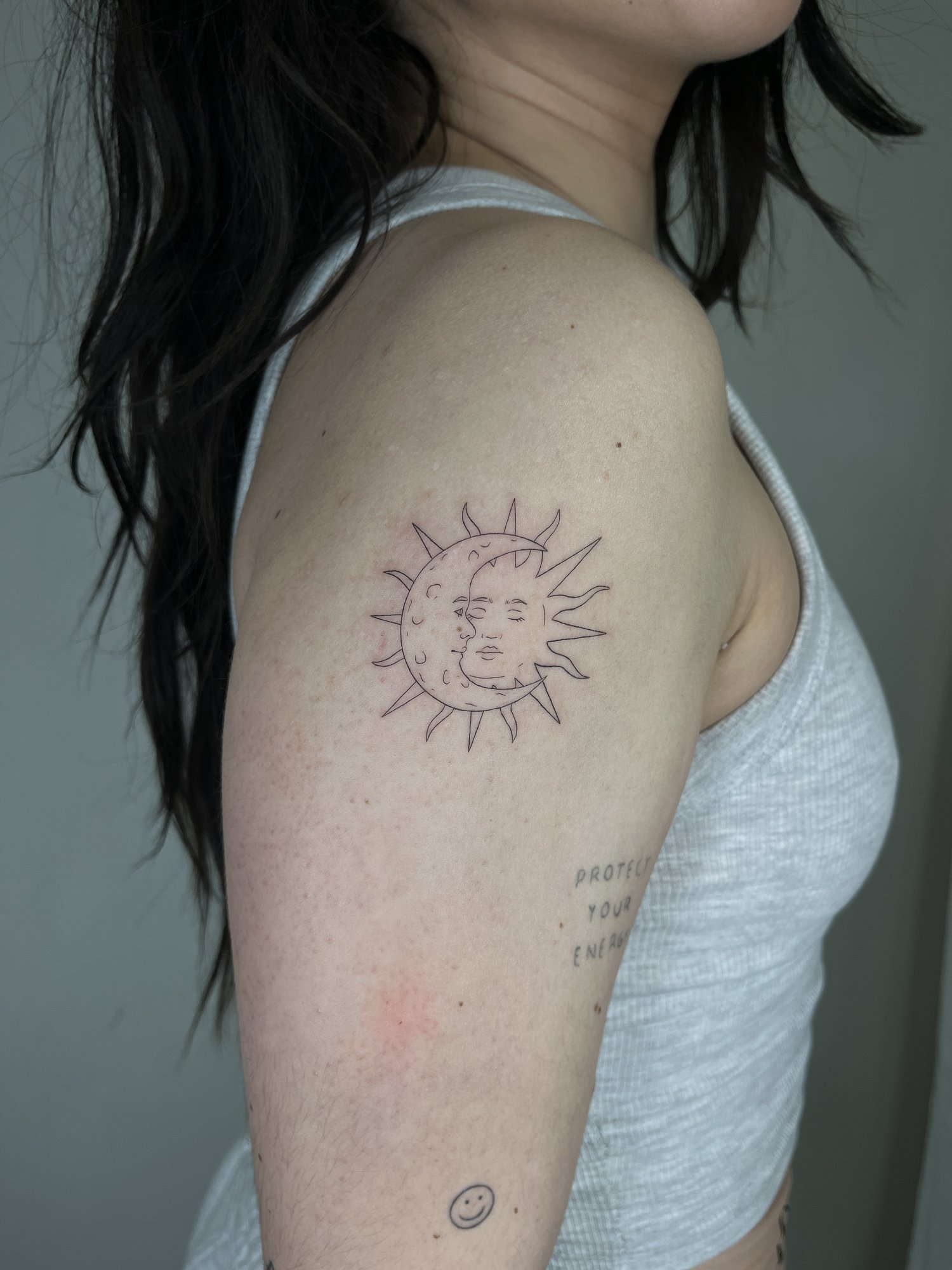 Tatuaje de sol luna rostros texto en brazo, línea fina