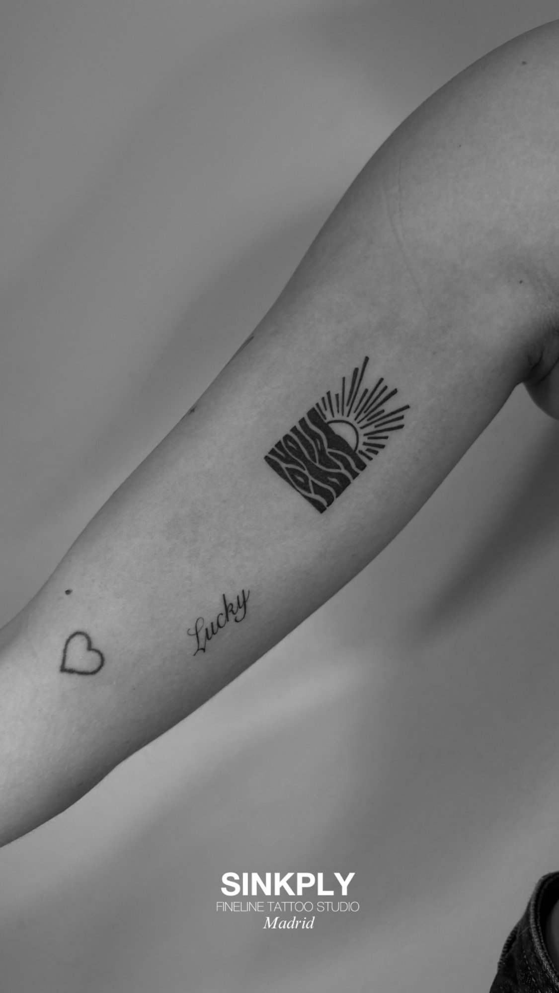 Tatuaje de sol oceano corazon lucky en antebrazo, línea fina